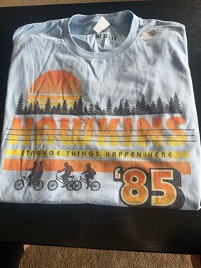 Netflix Light Blue Hawkins '85 Sunset Graphic Tee with Orange & Yellow Print